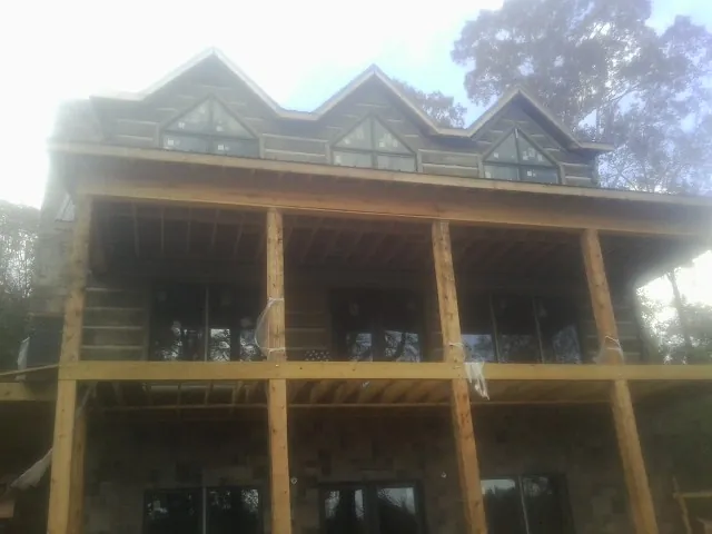 Dormers and porch framing on a large log home under construction — Roof Coating work by our crew in Yoncalla